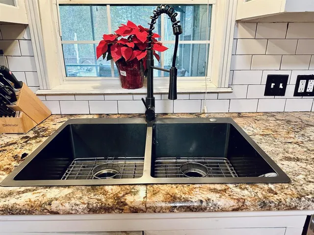 a kitchen sink with granite countertop a sink and a stove