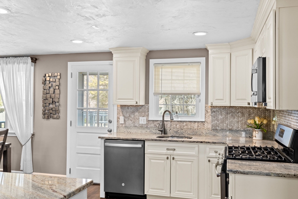 1368 Bay Road Stoughton, MA 02072 - Photo 15 of 42 a kitchen with stainless steel appliances granite countertop a sink stove and cabinets