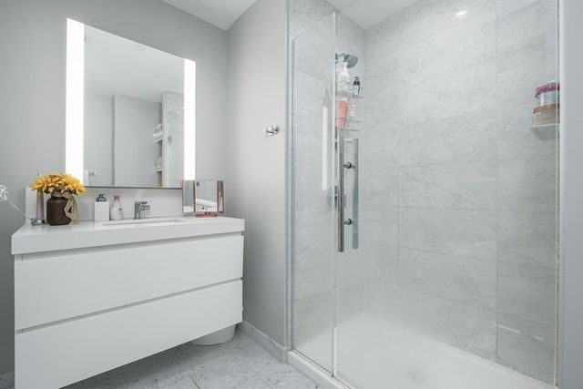 a bathroom with a sink vanity and shower