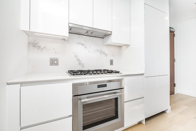 a stove top oven sitting inside of a kitchen