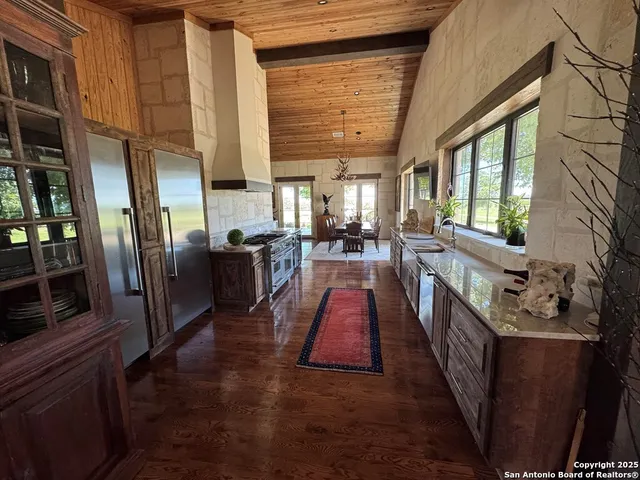 a kitchen with stainless steel appliances granite countertop a stove a sink and a dining table