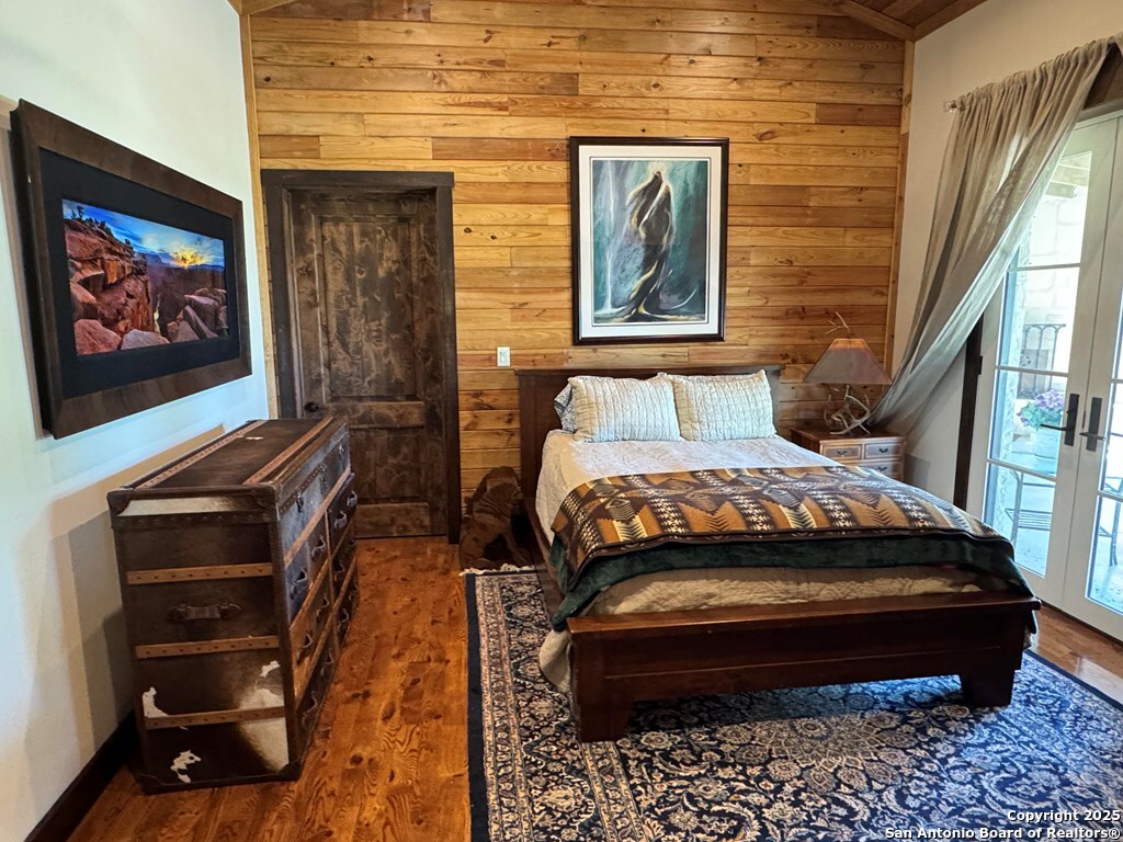 772 Luckenbach Road Fredericksburg, TX 78624 - Photo 39 of 86 a bedroom with a bed and a painting on the wall