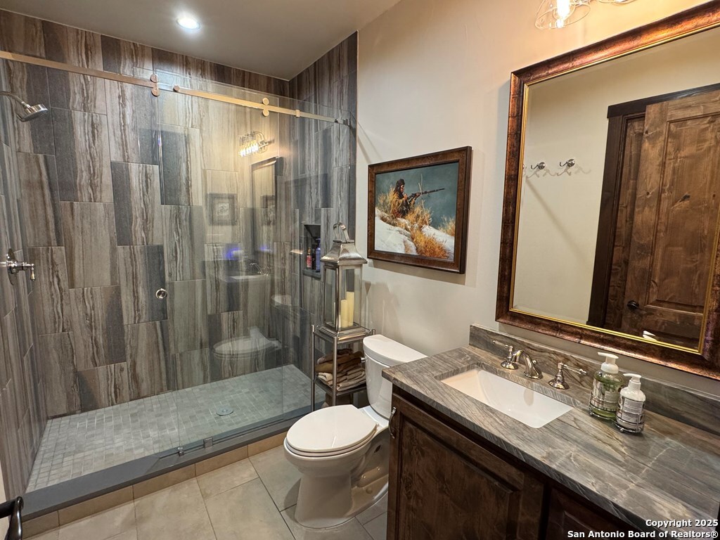 772 Luckenbach Road Fredericksburg, TX 78624 - Photo 43 of 86 a bathroom with a sink a toilet a mirror and shower