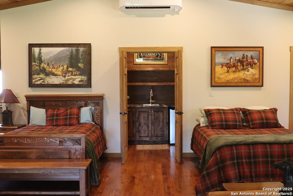 772 Luckenbach Road Fredericksburg, TX 78624 - Photo 50 of 86 a bedroom with a bed and a painting on the wall