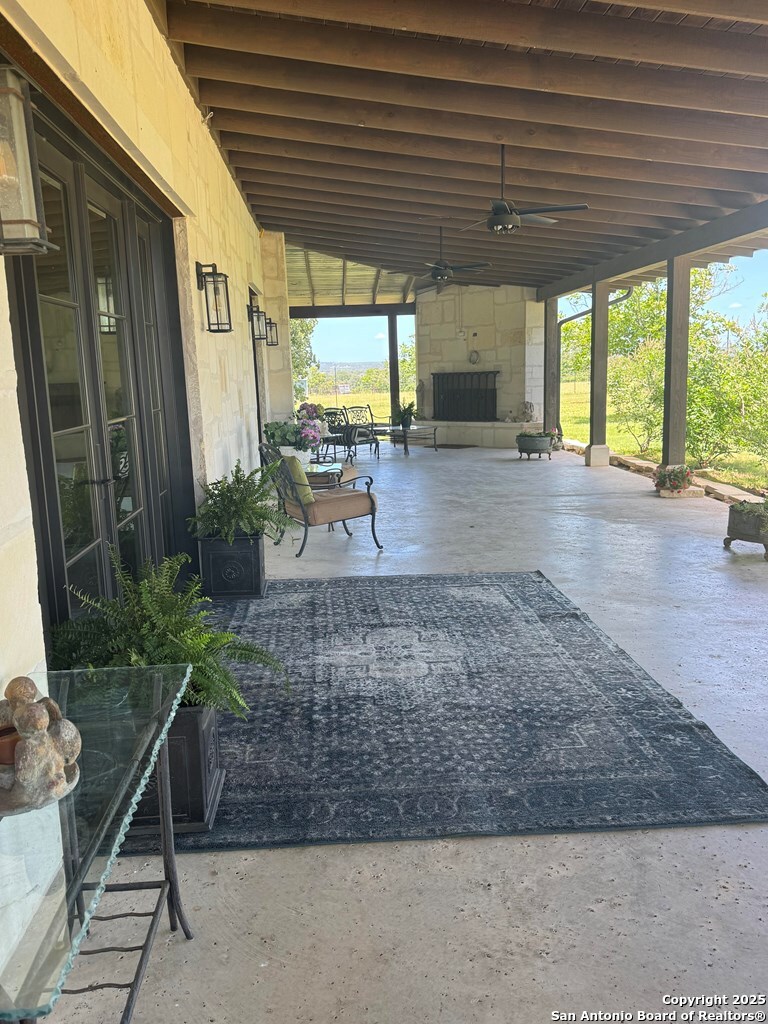 772 Luckenbach Road Fredericksburg, TX 78624 - Photo 6 of 86 a view of a patio with table and chairs potted plants with wooden floor