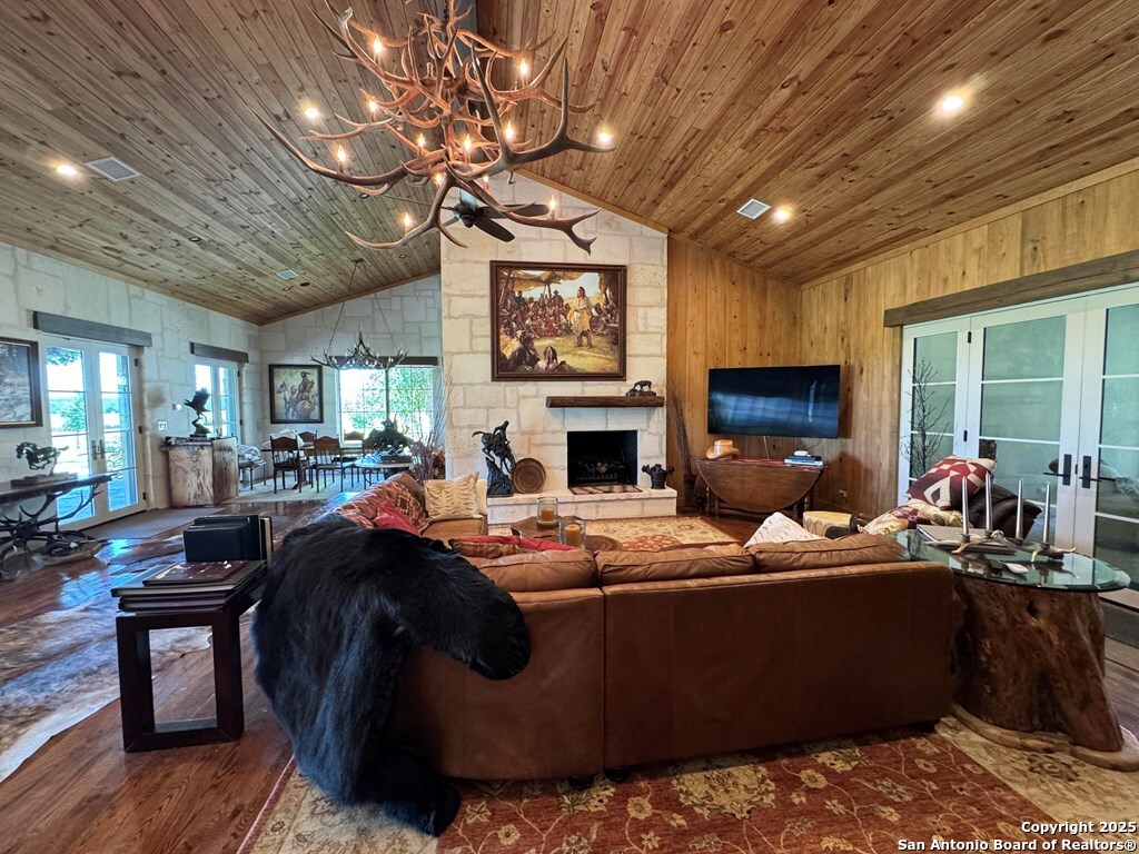 772 Luckenbach Road Fredericksburg, TX 78624 - Photo 8 of 86 a living room with furniture a fireplace and a flat screen tv