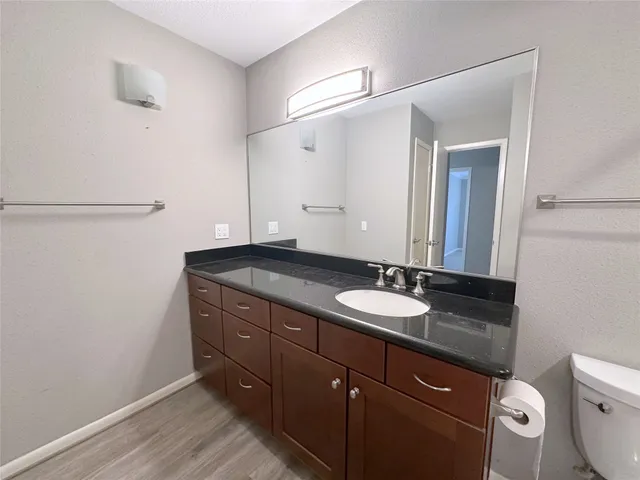 a bathroom with a granite countertop sink and a mirror