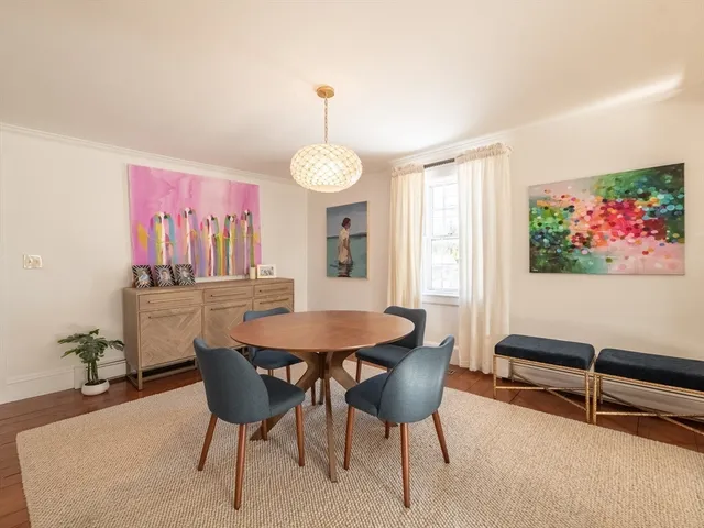 a living room with furniture a large window and wooden floor