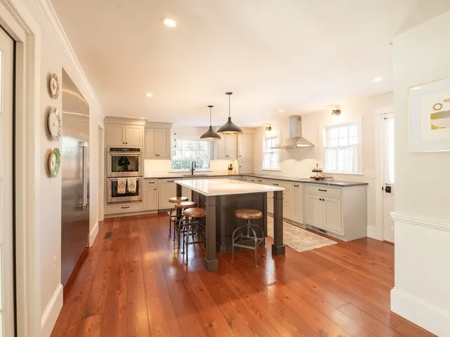 a kitchen with stainless steel appliances granite countertop a stove a sink dishwasher a refrigerator with a dining table and chairs