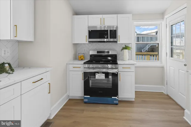 a kitchen with stainless steel appliances a stove microwave and sink