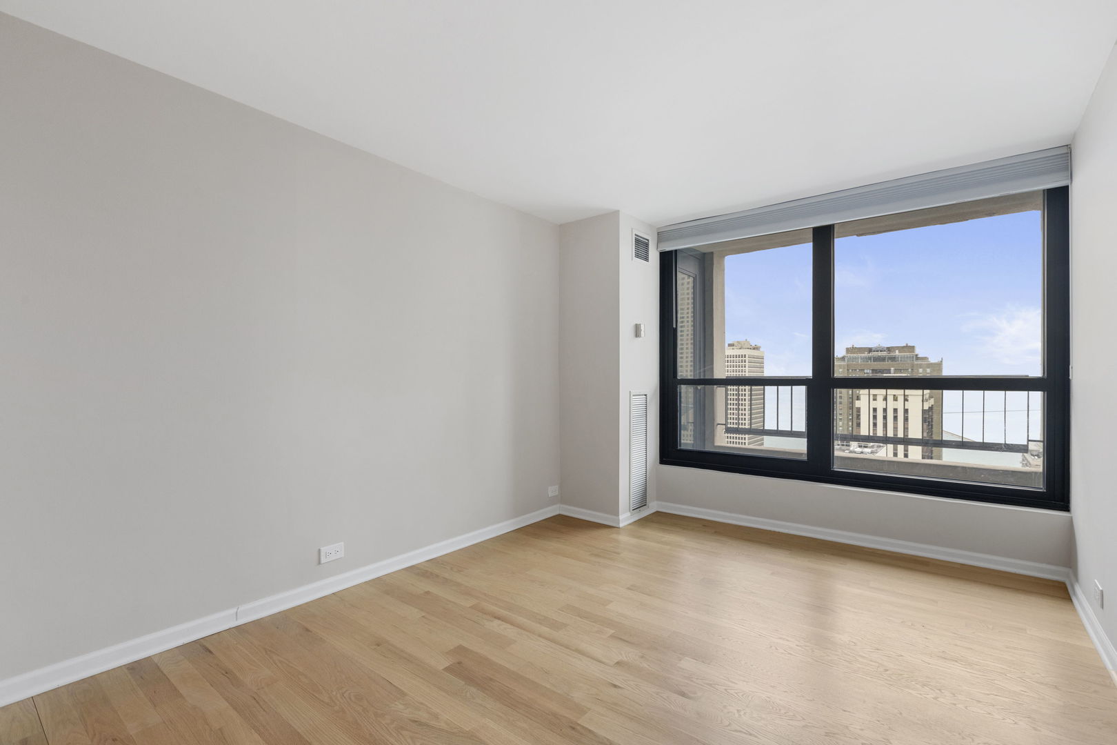 1030 North State Street, Unit 31E Chicago, IL 60610 - Photo 13 of 19 wooden floor in an empty room with a window