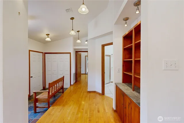 a view of hallway with stairs and wooden floor