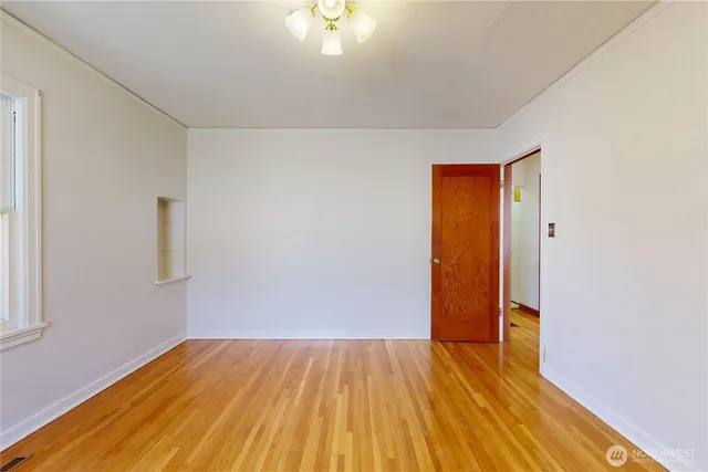 an empty room with wooden floor and closet