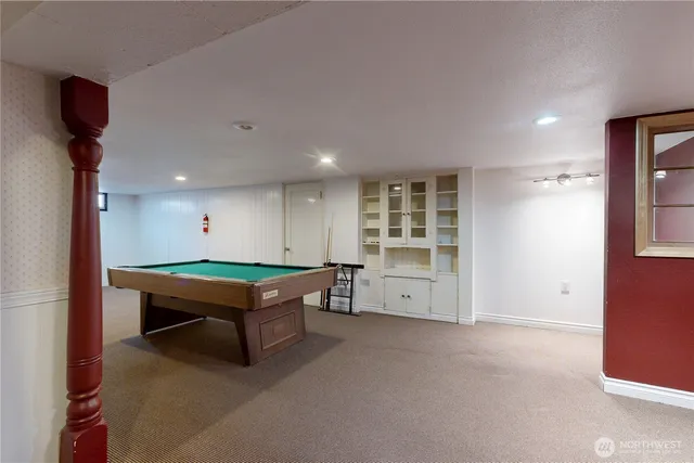 a room with pool table and windows