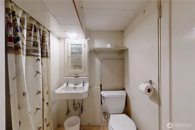 a bathroom with a toilet sink and mirror