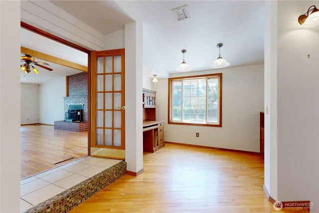 a view of an empty room with window and wooden floor