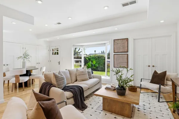 a living room with furniture potted plant and a large window