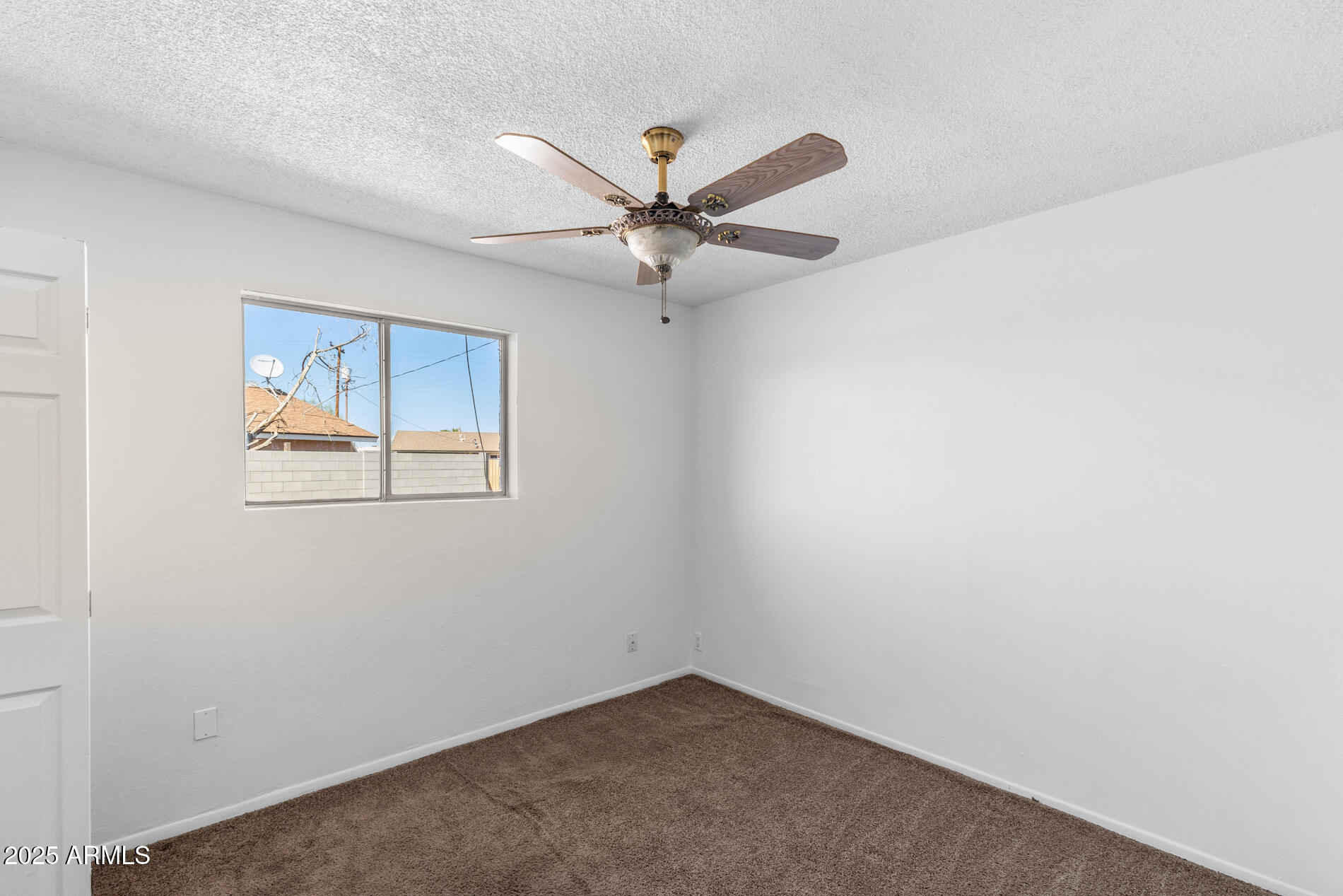 2230 East Chipman Road Phoenix, AZ 85040 - Photo 16 of 26 an empty room with a window and a fan