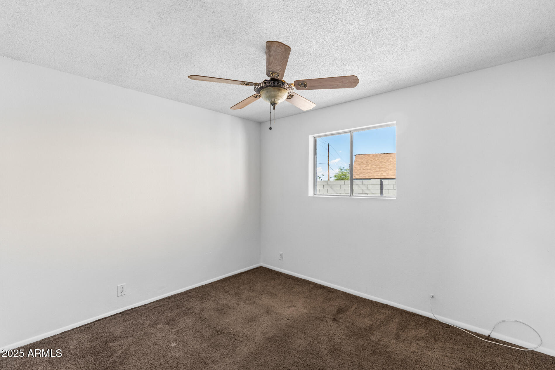 2230 East Chipman Road Phoenix, AZ 85040 - Photo 18 of 26 an empty room with a window and a fan