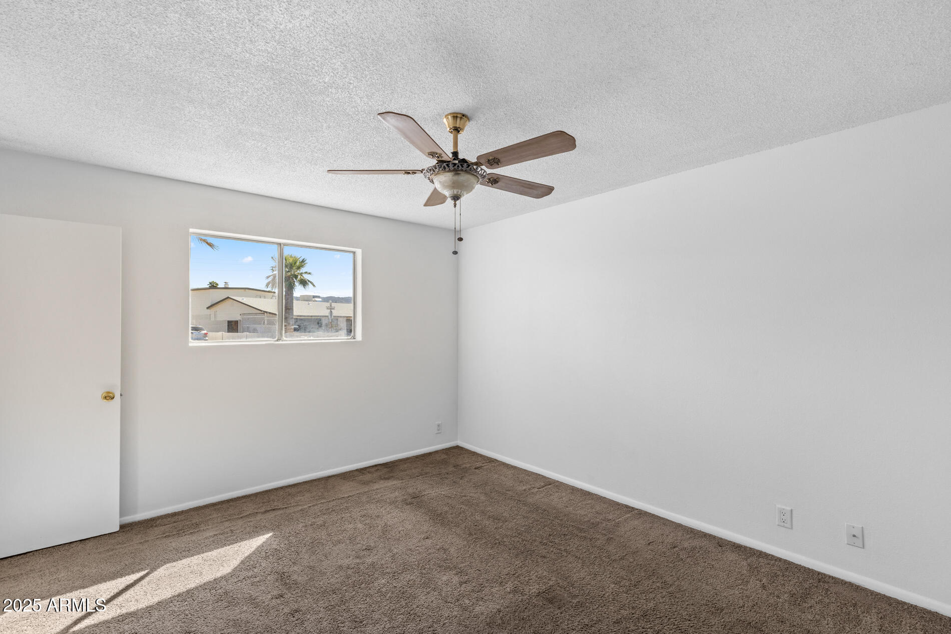 2230 East Chipman Road Phoenix, AZ 85040 - Photo 19 of 26 an empty room with a window and a ceiling fan