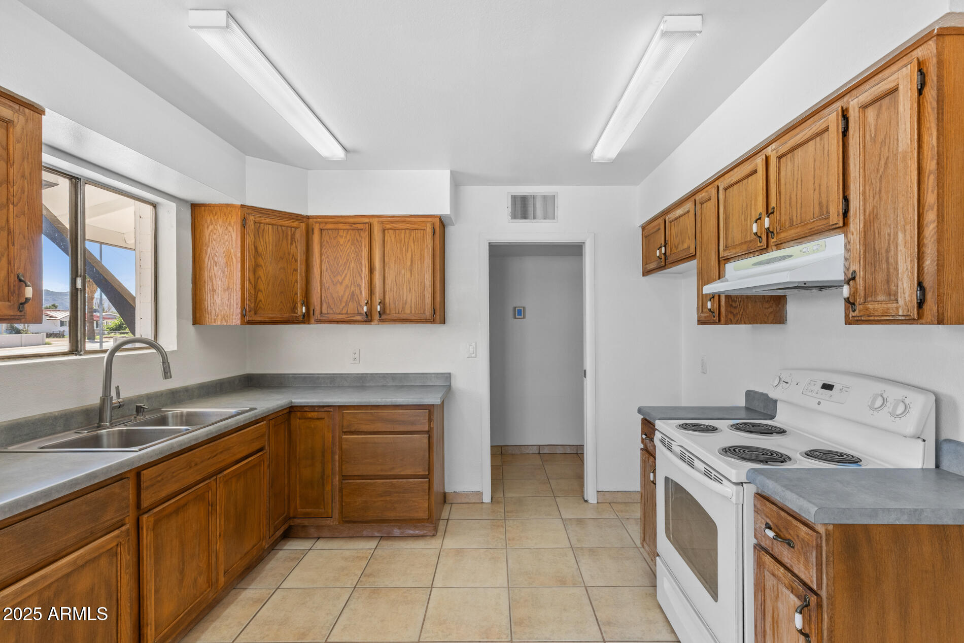 2230 East Chipman Road Phoenix, AZ 85040 - Photo 7 of 26 a kitchen with a sink stove top oven and cabinets