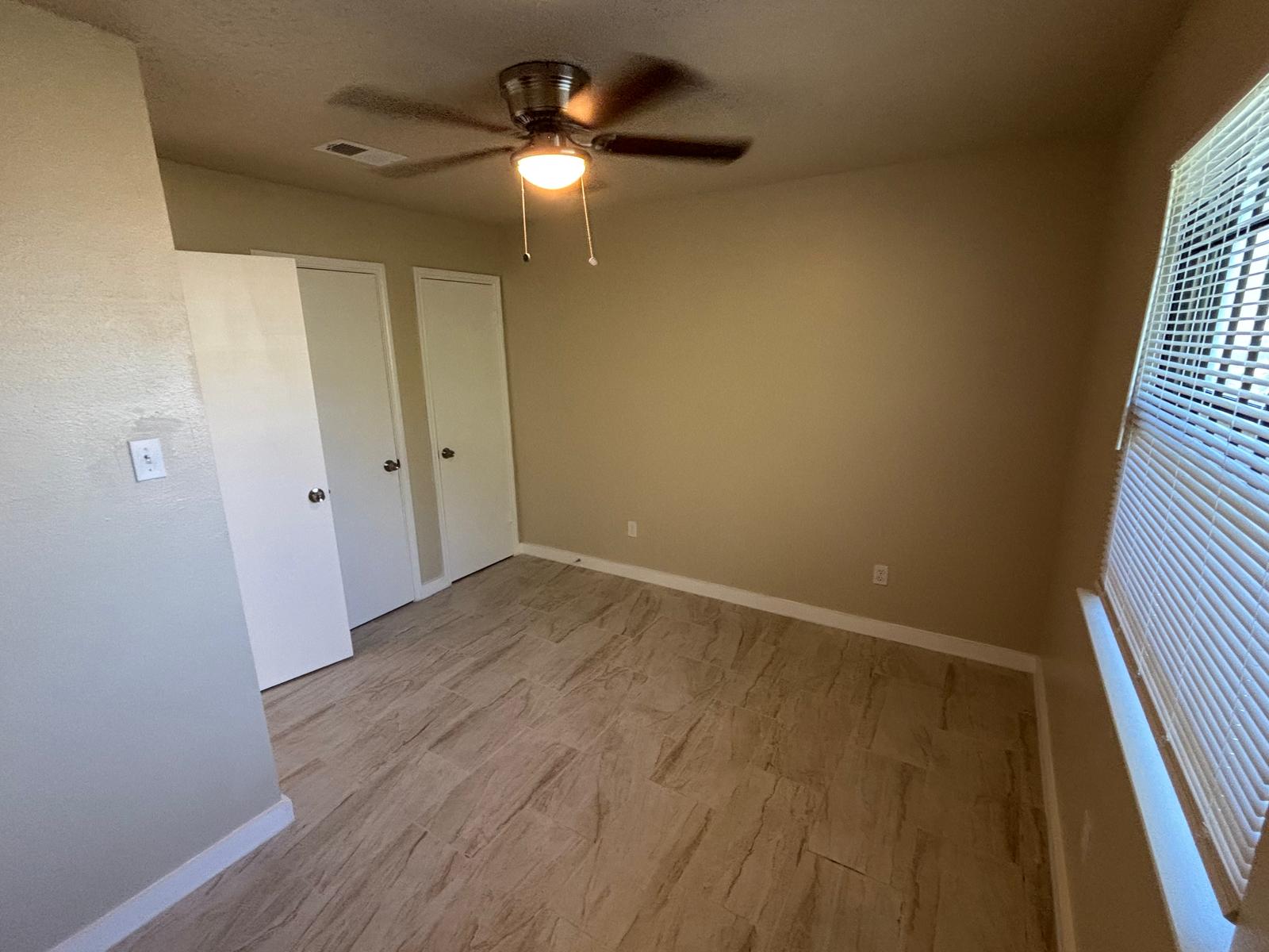 4609 East 12th Street, Unit 4 Austin, TX 78721 - Photo 8 of 14 Wood-look tile flooring and a large window define this versatile secondary space.