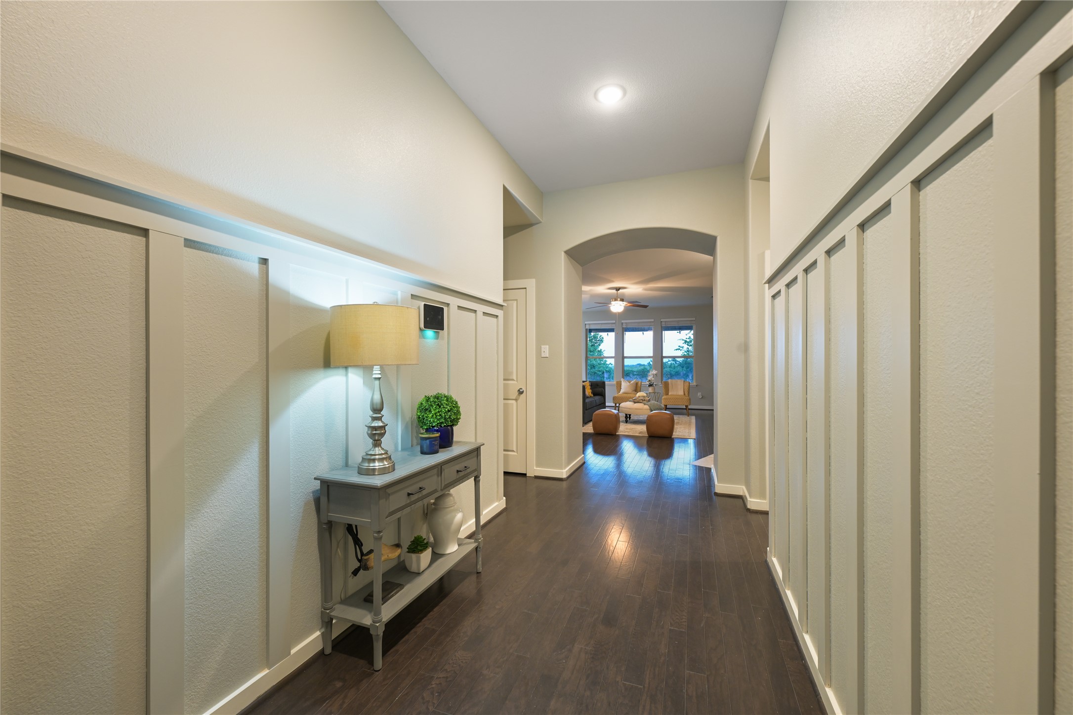 188 Nautical Loop Kyle, TX 78640 - Photo 4 of 38 Board and batten wainscoting highlights a welcoming entryway leading to an arched great room beyond.