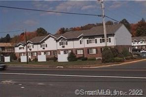 a view of a white house with a street