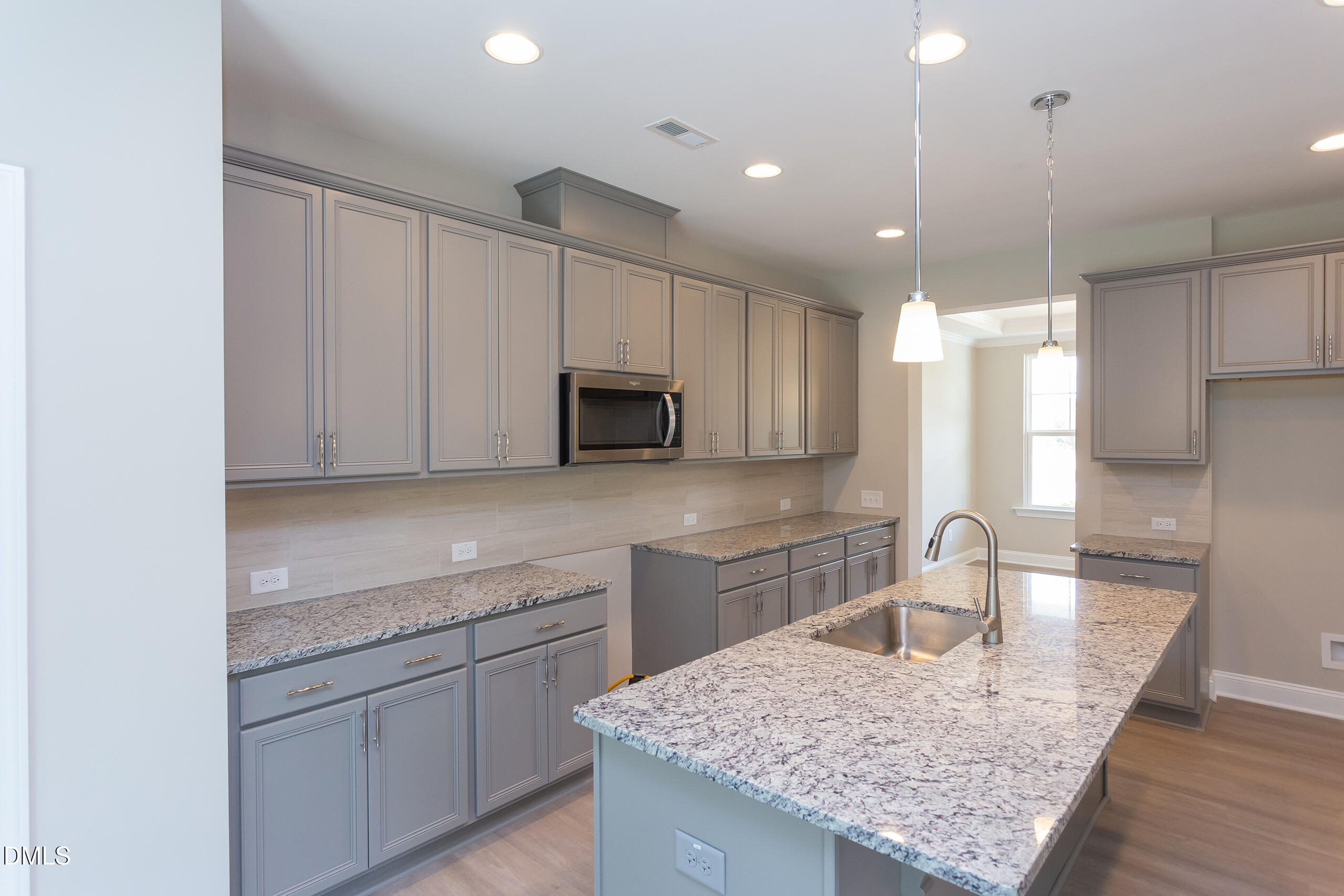 263 Gilliland Road Siler City, NC 27344 - Photo 7 of 31 a kitchen with kitchen island granite countertop a sink stainless steel appliances and white cabinets
