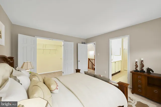 a spacious bedroom with a bed and wooden floor