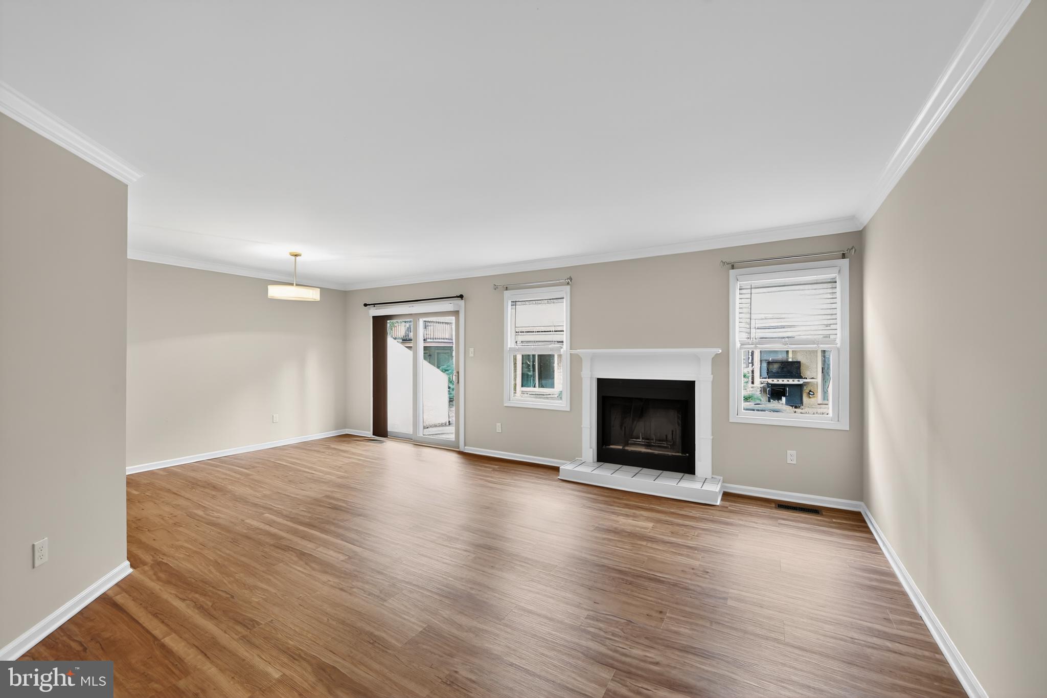 107 Reveille Road, Unit 107 Chesterbrook, PA 19087 - Photo 10 of 22 an empty room with wooden floor fireplace and windows