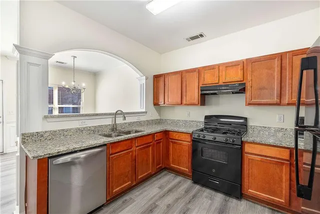 a kitchen with stainless steel appliances granite countertop a sink stove and cabinets