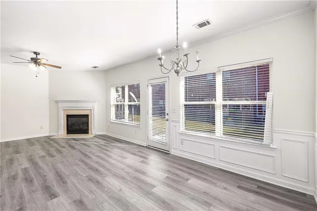 a view of a livingroom with a chandelier a fireplace and windows