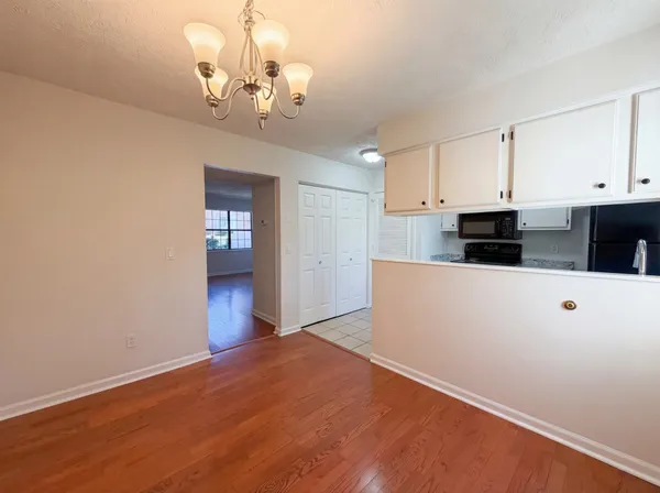 a view of a kitchen with wooden floor and cabinets