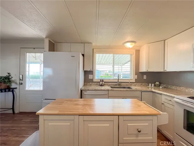 a kitchen with a sink a stove top oven and cabinetry