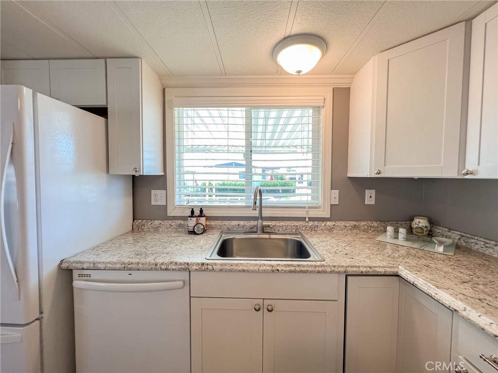 650 Channel Way, Unit 650 Needles, CA 92363 - Photo 17 of 60 a kitchen with granite countertop a sink and a window