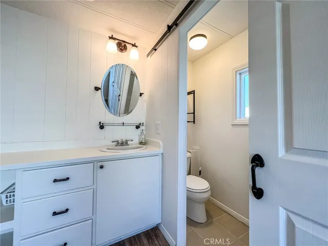 a bedroom with a bed and a lamp on dresser