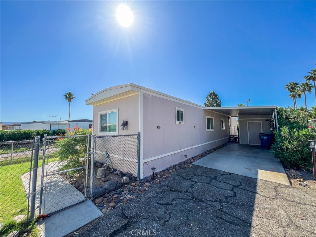 650 Channel Way, Unit 650 Needles, CA 92363 - Photo 52 of 60 a white house with a yard and table and chairs under an umbrella