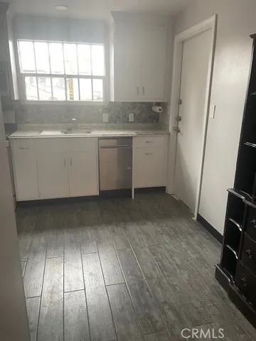 a view of a kitchen with wooden floor and electronic appliances
