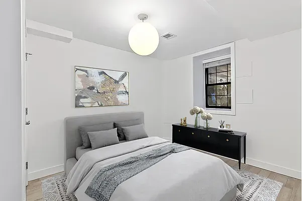 a bedroom with bed and a chandelier