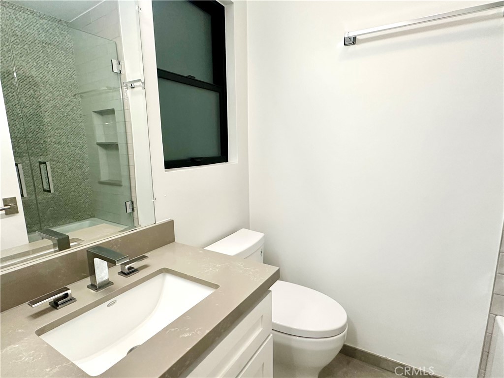 301 Ashland Avenue, Unit 4 Santa Monica, CA 90405 - Photo 16 of 24 a bathroom with a granite countertop sink toilet and shower
