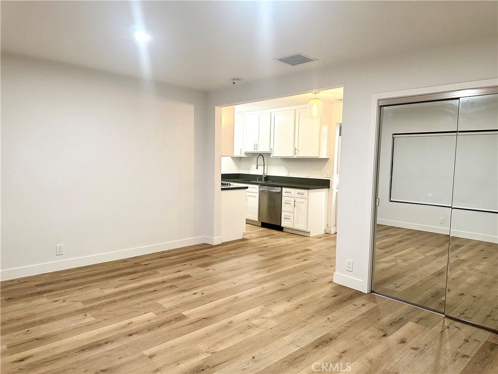 301 Ashland Avenue, Unit 4 Santa Monica, CA 90405 - Photo 4 of 24 an empty room with wooden floor kitchen view and a window