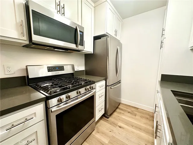 a kitchen with stainless steel appliances granite countertop a stove microwave and refrigerator