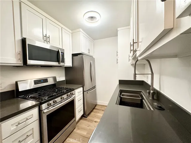 a kitchen with a stove a microwave and refrigerator