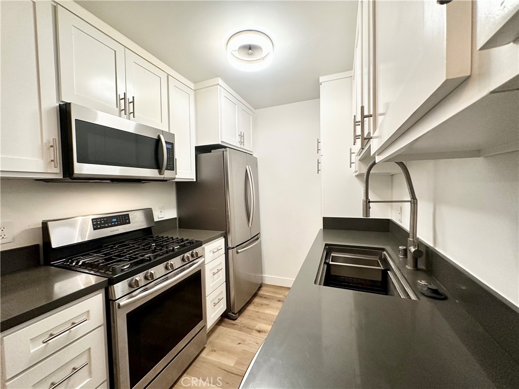 301 Ashland Avenue, Unit 4 Santa Monica, CA 90405 - Photo 7 of 24 a kitchen with a stove a microwave and refrigerator