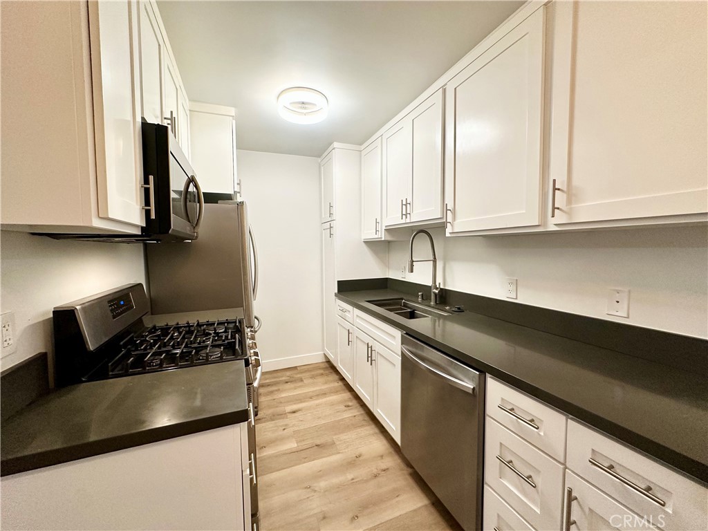 301 Ashland Avenue, Unit 4 Santa Monica, CA 90405 - Photo 8 of 24 a kitchen with granite countertop a sink a stove and cabinets