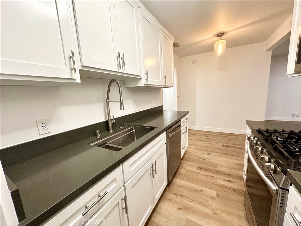 301 Ashland Avenue, Unit 4 Santa Monica, CA 90405 - Photo 9 of 24 a kitchen with granite countertop a sink stove and cabinets