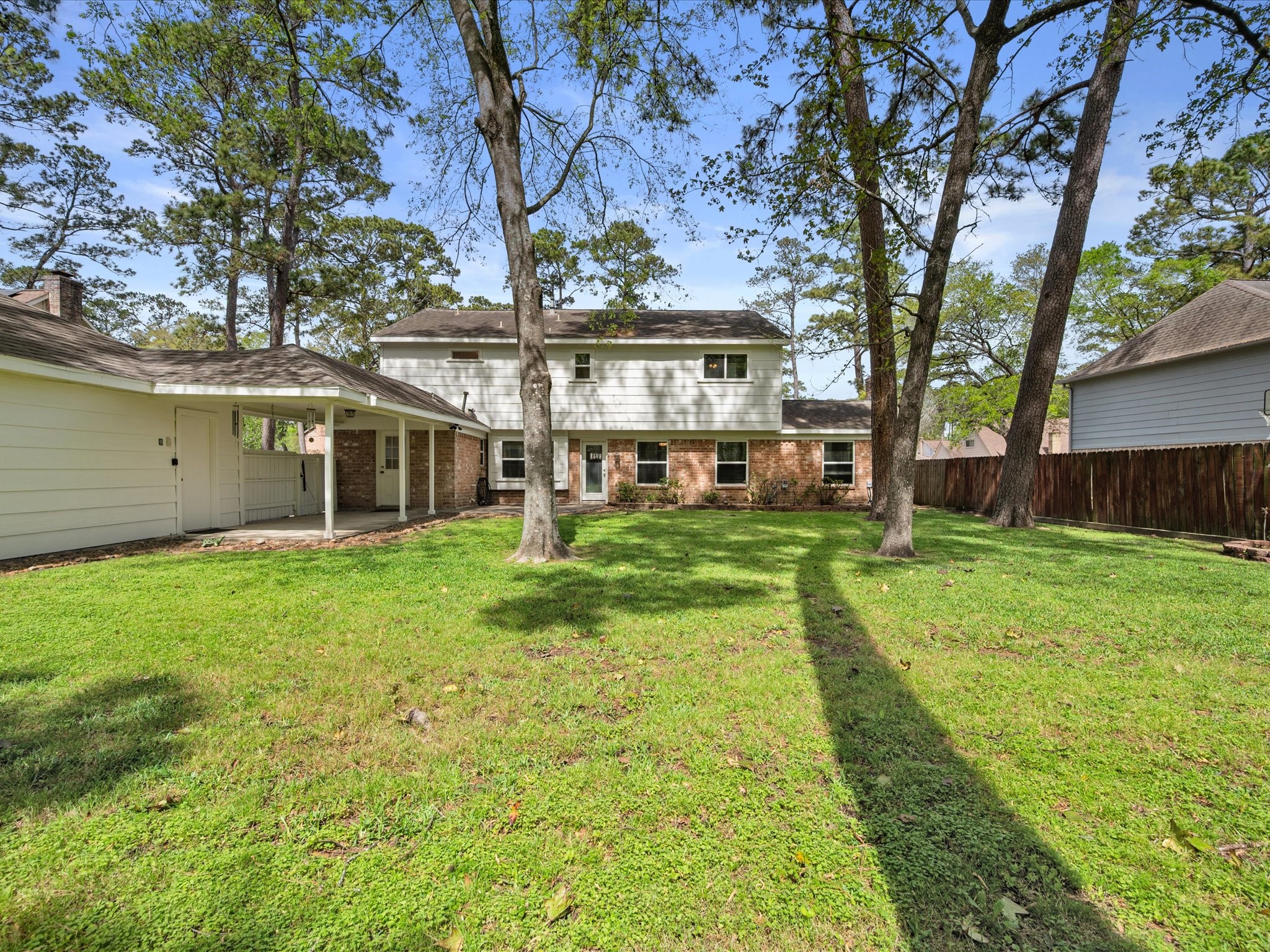 5223 Ashmere Lane Spring, TX 77379 - Photo 44 of 50 Step outside to a spacious backyard shaded by mature trees. Enjoy a large patio and covered walkway to the detached garage.