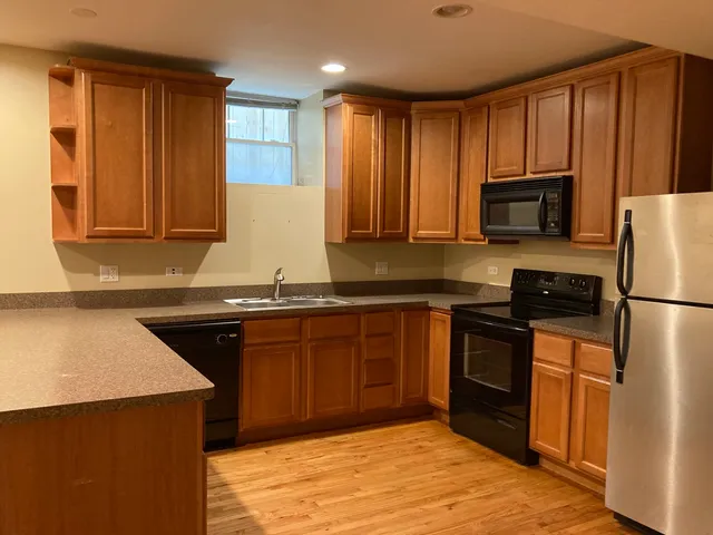a kitchen with granite countertop wooden cabinets and a stove top oven