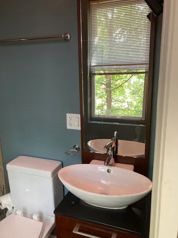 a bathroom with a sink toilet and mirror